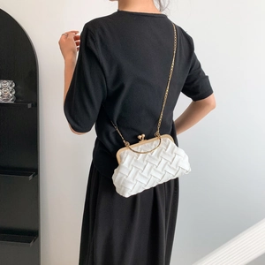 Minimalist white woven shell bag with gold chain strap worn by a female model