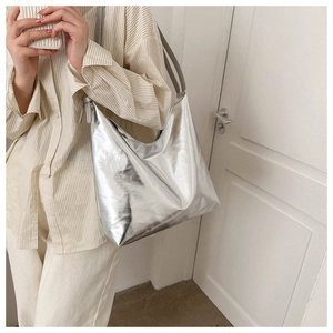 Detailed view of silver metallic shoulder tote bag with shiny reflective finish and minimalist design