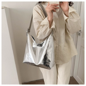 Detail of silver metallic mirror tote bag with adjustable shoulder strap and glossy finish