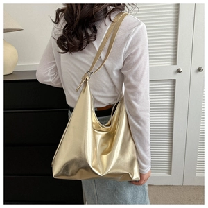 Detailed macro view of high-shine metallic gold hobo tote bag texture and design