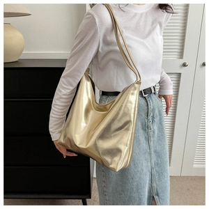Detail of metallic gold tote bag showing luxury lychee texture and soft shoulder straps