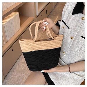 Detail of hand-held woven bucket bag with contrast beige and black texture