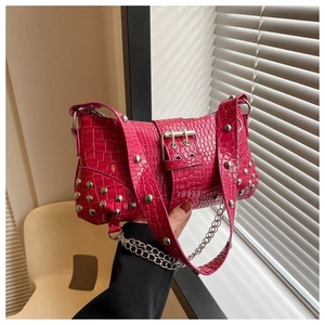 Detail der rosaroten Handtasche aus Krokodillederimitat mit silbernen Nieten und Kette