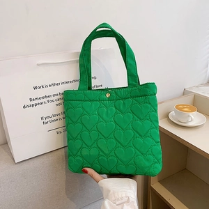 Borsa tote trapuntata verde con motivo a cuore e chiusura dorata elegante
