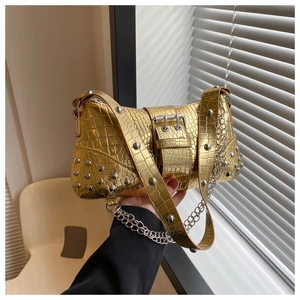 Detail der goldenen Handtasche mit Krokodilprägung, Silbernieten und Metallkette
