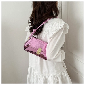 Detail of pink mirror leather shoulder bag featuring a gold square lock and knotted strap