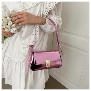 Detail view of pink metallic underarm bag with knot strap and gold buckle