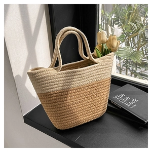Detail of a two-tone woven bucket bag featuring a natural straw texture and beige finish