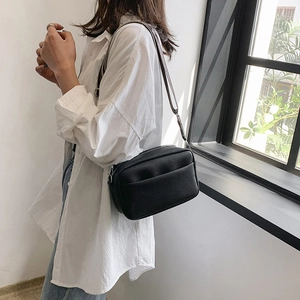 Minimalist black lychee leather camera bag with striped wide shoulder strap for women