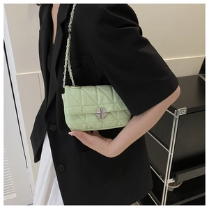 Detail shot of pistachio green quilted shoulder bag with silver clasp and chain strap