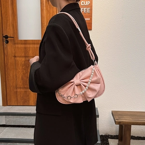 Pink bow-shaped shoulder bag with decorative pearl and floral silver chain detail