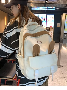 Detailed view of cream and brown backpack with cute rabbit ears and dual buckle closure