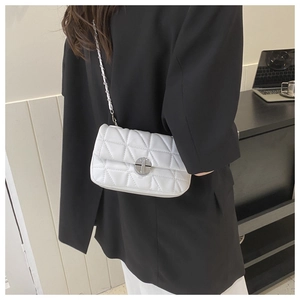 Detail view of a white quilted crossbody bag with silver chain strap and metal clasp