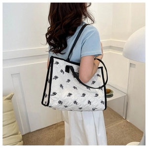 Detail of white tote bag with black rose jacquard pattern and contrast trim design