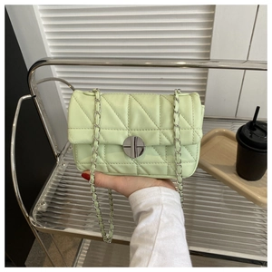 Detail view of mint green quilted PU leather shoulder bag with silver chain strap