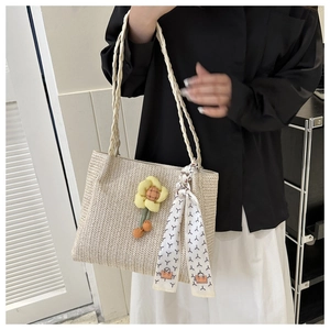 Detailed macro view of beige woven tote bag with 3D floral charm and geometric scarf wrap