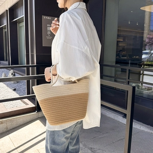 Chic two-tone woven bucket bag featuring cream and light brown patchwork design