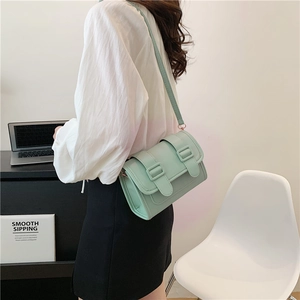 Minimalist mint green square crossbody bag shown on model with clean office background