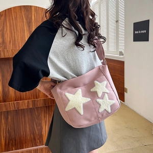 Pink canvas tote bag with yellow plush stars shown in a lifestyle indoor scene