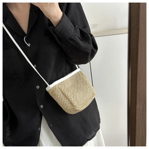 Detail of handwoven mini crossbody bag with white leather straps in a minimal style
