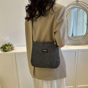 Vintage black woven tote bag with gold logo on model in elegant minimalist room