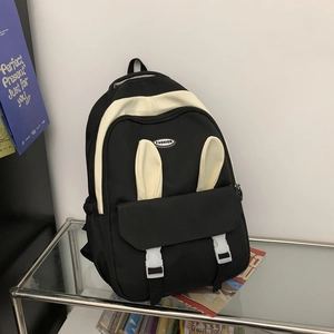 Detail view of stylish black and white backpack with cute rabbit ears and fashion label