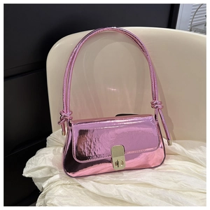 Detail view of pink metallic underarm bag with knot strap and golden metal buckle
