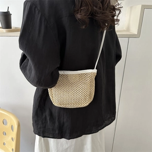 Minimalist woven bucket crossbody bag in beige straw with white faux leather straps