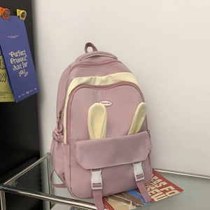 Detail of pink and white backpack with cute rabbit ears and fashion rubber label