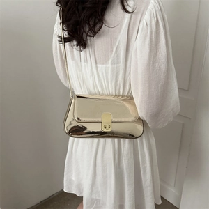 Minimalist metallic gold shoulder bag for women styled with a white dress for a chic look