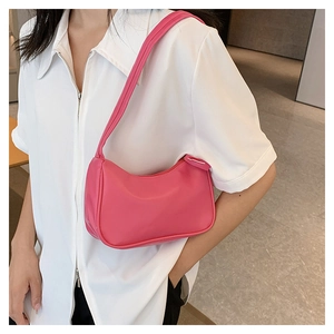 Close-up of bright pink shoulder bag worn by model showing smooth faux leather texture