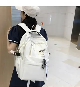 Détail d'un sac à dos blanc en nylon avec boucle latérale et pendentif en damier stylé