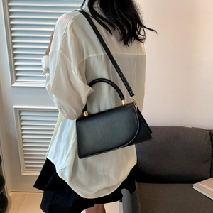 Sac bandoulière carré minimaliste en cuir noir avec ferrures métalliques dorées