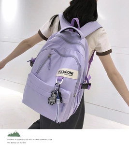 Vue détaillée du sac à dos violet clair imperméable avec pendentif ours à carreaux