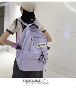 Détail du sac à dos en nylon lilas avec des breloques d'ours et des poches zippées