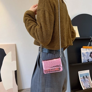 Pink metallic crossbody bag with glossy crocodile pattern and silver chain strap
