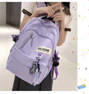 Gros plan détaillé d'un sac à dos décontracté violet avec étiquette blanche et breloque ours