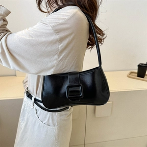 Sac sous le bras noir brillant à boucle carrée porté par un mannequin en studio