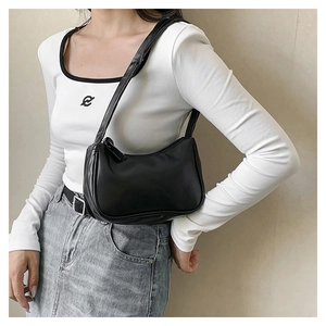 Detail of minimalist black semi-circle underarm bag in premium PU leather on model
