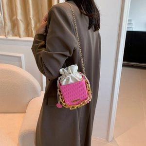 Magenta pleated shoulder bag with gold chain and interior drawstring pouch shown on model