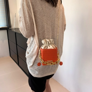 Chic orange textured leather mini bucket bag with gold chain and drawstring closure