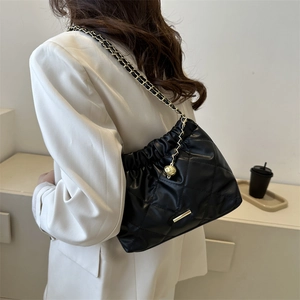 Classic black quilted crossbody bag with gold chain strap and spherical charm detail