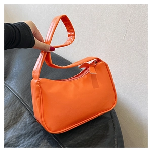 Detail of vibrant orange hobo shoulder bag with a secure zipper and flat handle