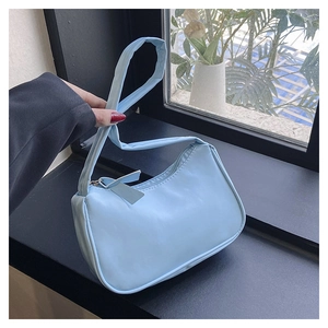 Close-up of the smooth light blue PU leather surface and metal zipper of the underarm bag