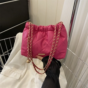 Sac fourre-tout matelassé magenta chic avec bandoulière dorée et pendentif boule dorée