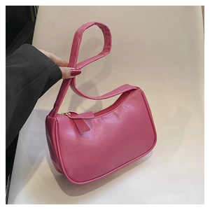 Detail view of hot pink crescent underarm bag with zipper closure and ribbon charm