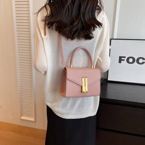 Rosafarbene Leder Mini Umhängetasche mit goldenen Details in stilvollem Lifestyle-Ambiente
