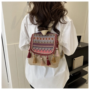 Détail d'un sac à dos bohème avec motifs géométriques colorés et glands décoratifs