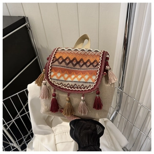 Gros plan d'un sac à dos tissé bohème avec motifs géométriques et détails de glands colorés