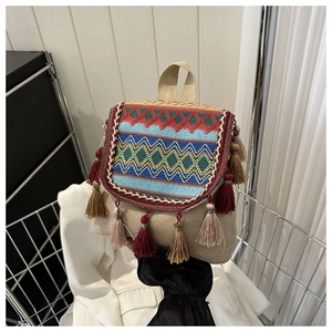 Détail d'un sac à dos ethnique avec broderies ondulées colorées et pampilles à franges